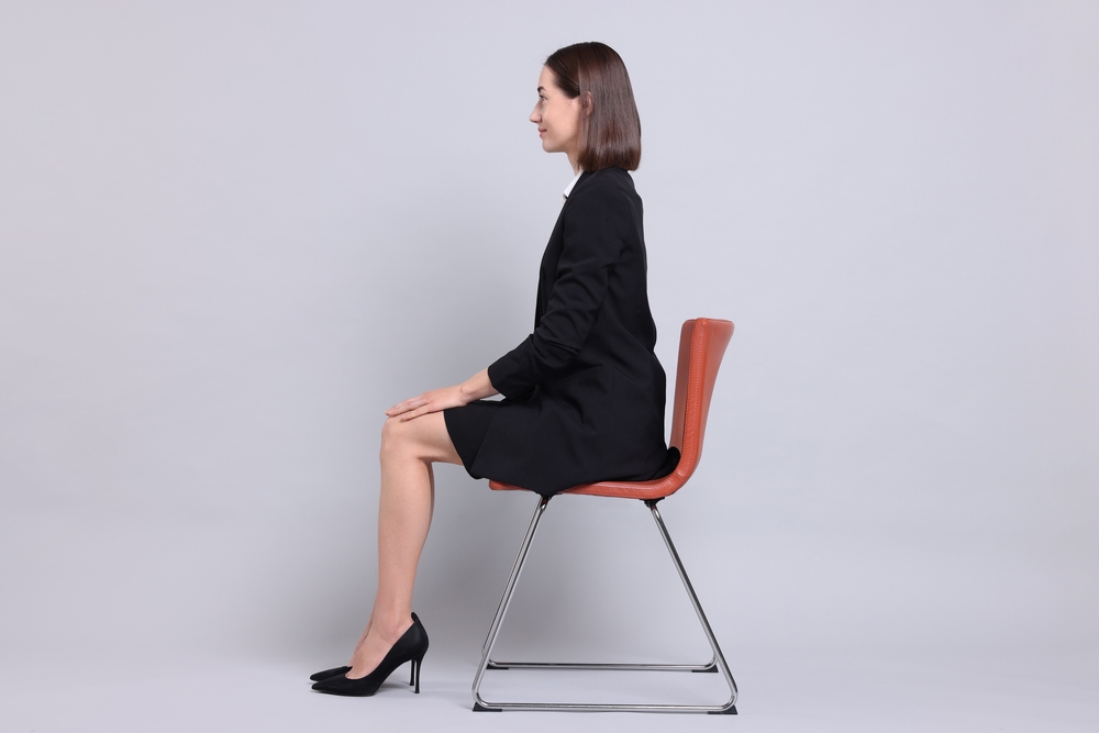 正しい姿勢で座るスーツを着た女性