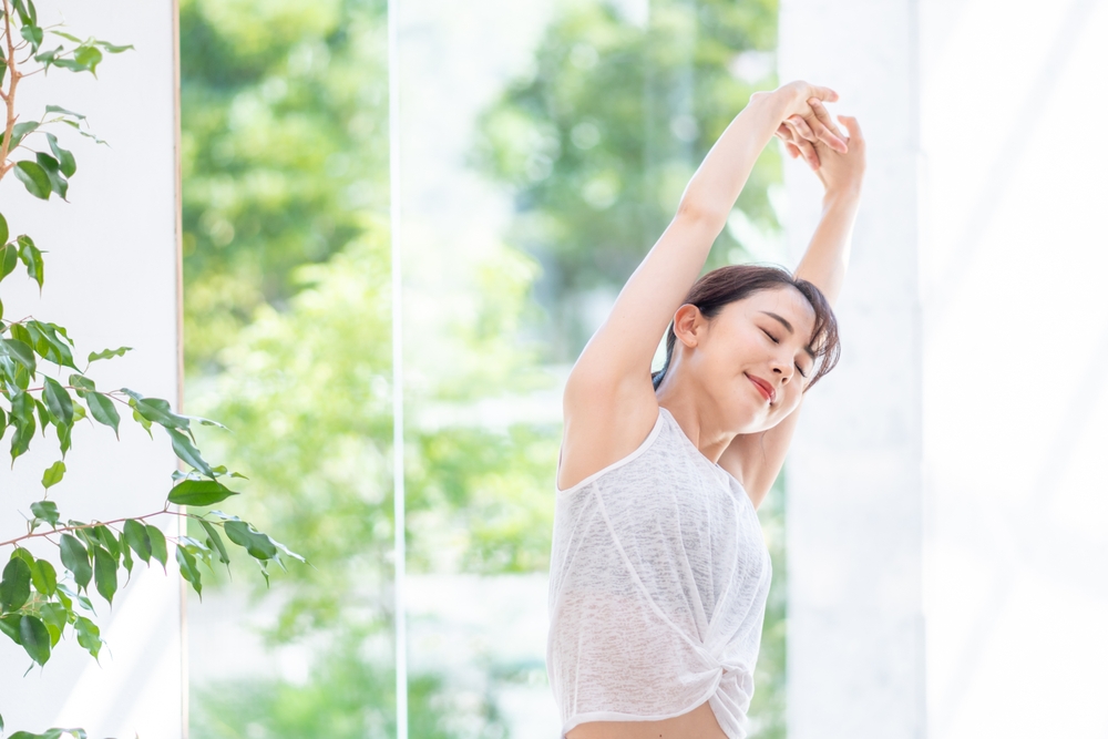 腕を上げてストレッチをする女性