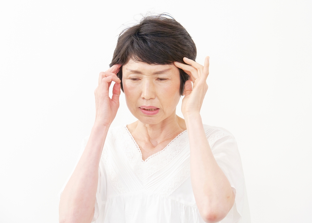 こめかみに痛みを感じている女性