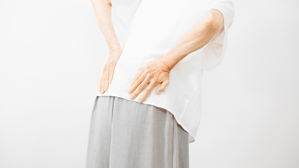 腰を抑えている人