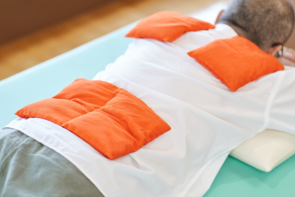 腰を温めている男性