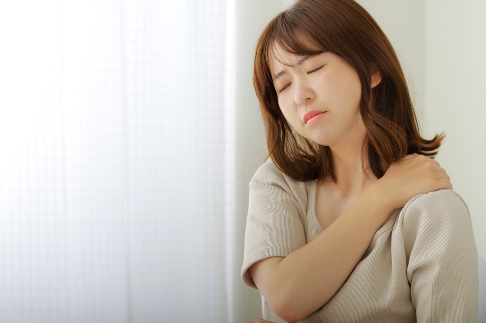 左肩のコリに苦しむ女性