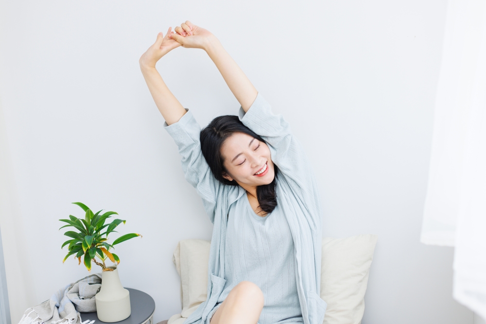 腕を伸ばしてストレッチをする女性