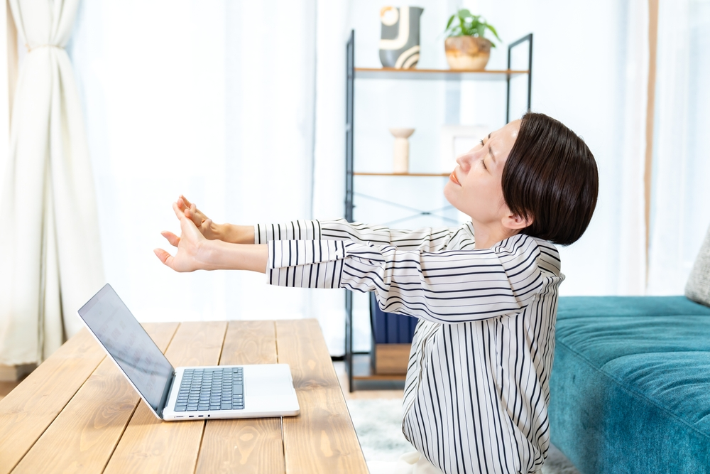 伸びをして血行を良くしている女性