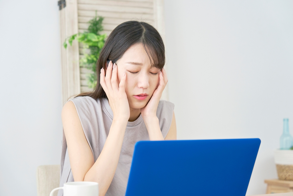夏バテによる頭痛の解消方法を調べる女性