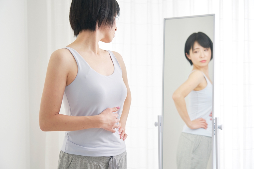 姿見で背中を確認する女性