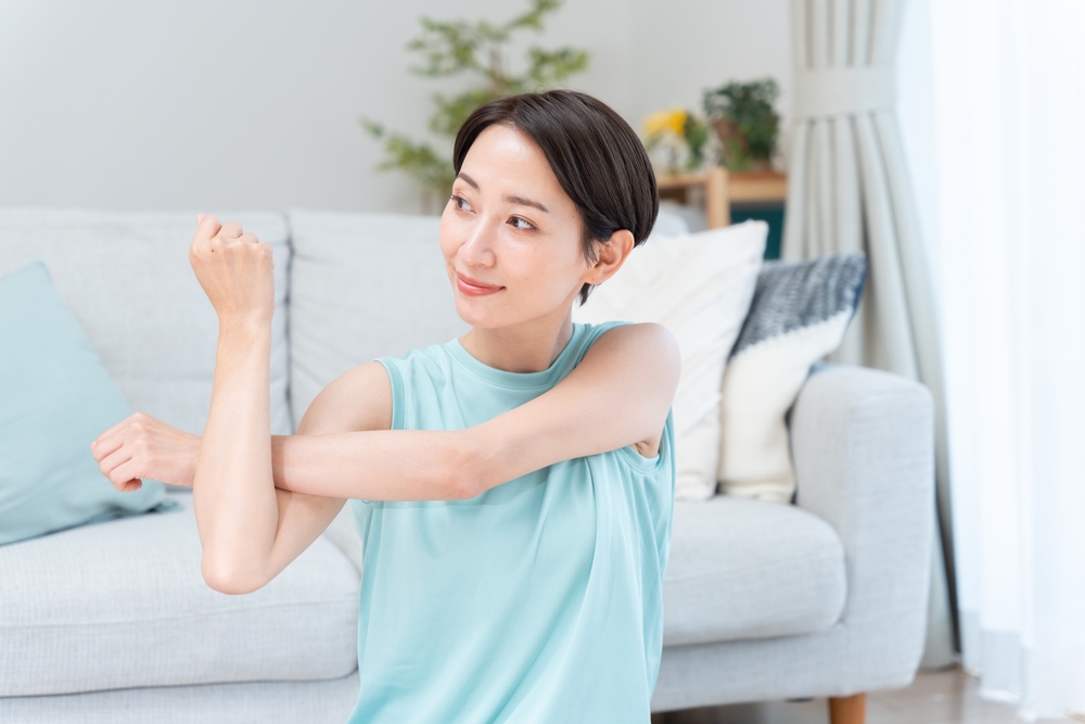 室内でストレッチする女性