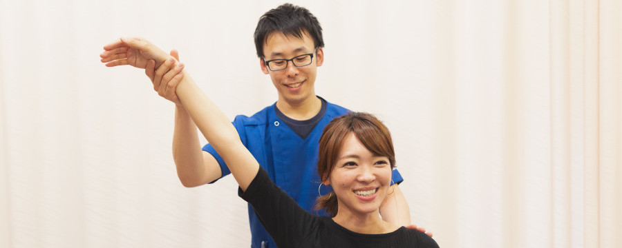 肩の可動域を確認する整体師