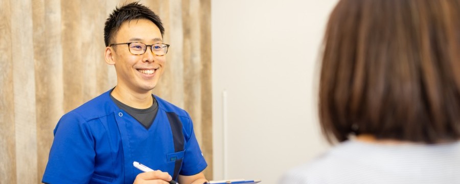 患者の話をメモする整体師