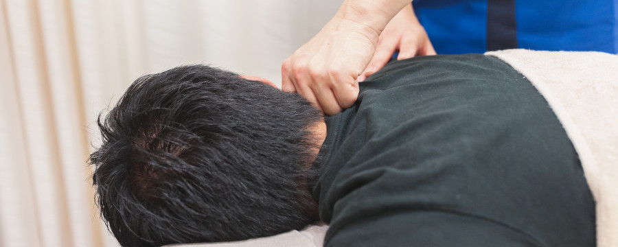 頭痛を伴う肩こりで整体院に来ている男性