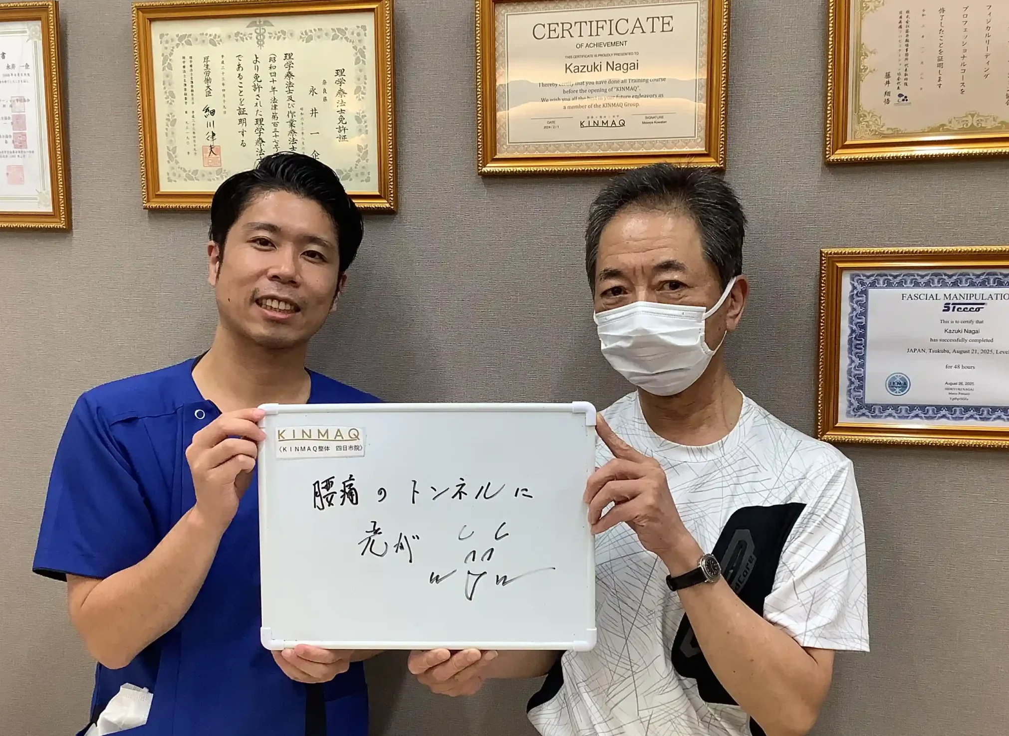 四日市の整体院で腰痛の改善のために通院していた男性の改善実績として。施術後のご本人と担当する理学療法士が一緒に『腰痛のトンネルに光が』と書いたホワイトボードを持ち、担当した理学療法士と2ショットを撮影したときの写真。