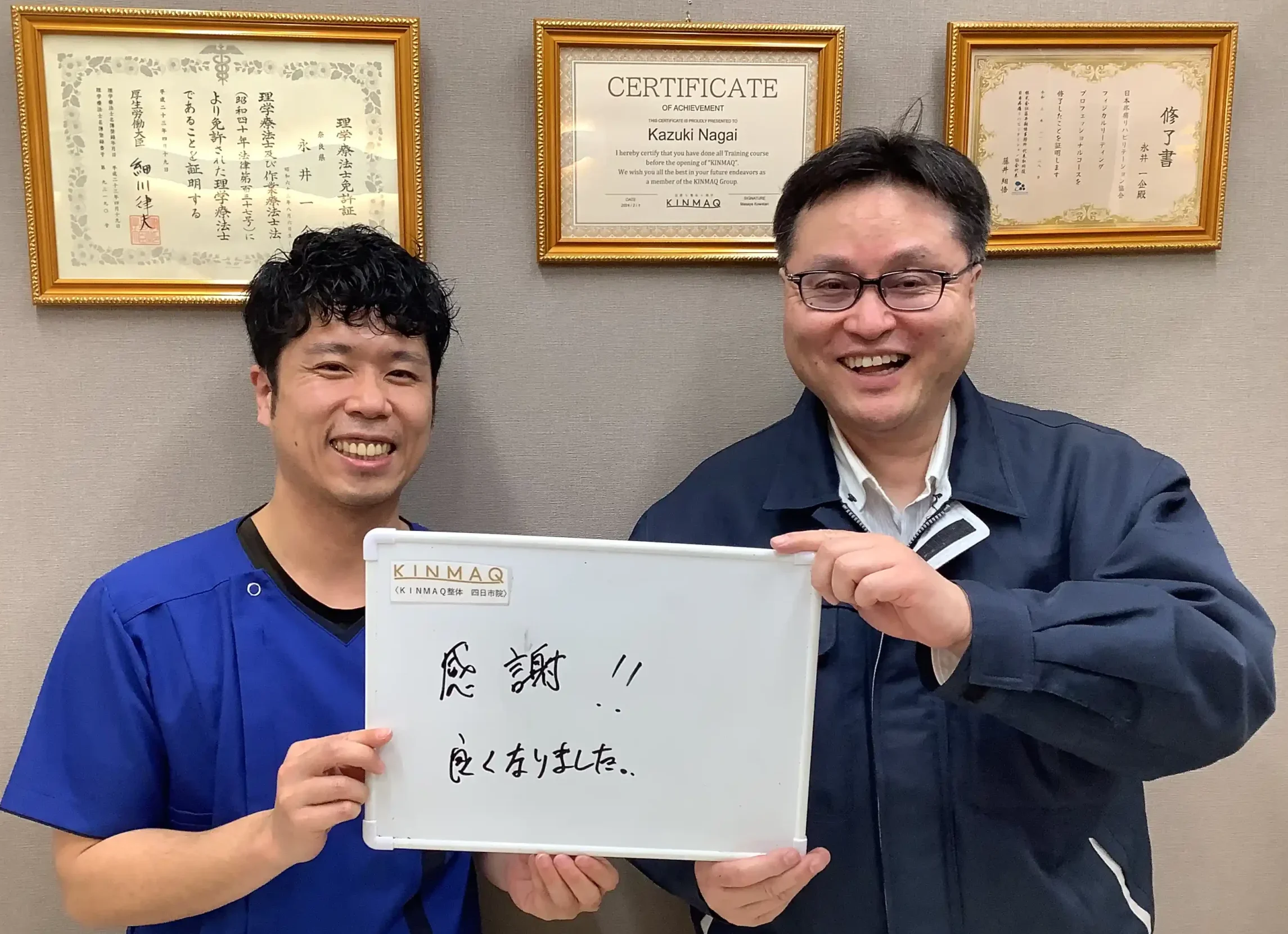 四日市の整体院で手のしびれの改善のために通院していた男性の改善実績として。施術後のご本人が『感謝！！良くなりました。』と書いたホワイトボードを持ち、担当した理学療法士と2ショットを撮影したときの写真。